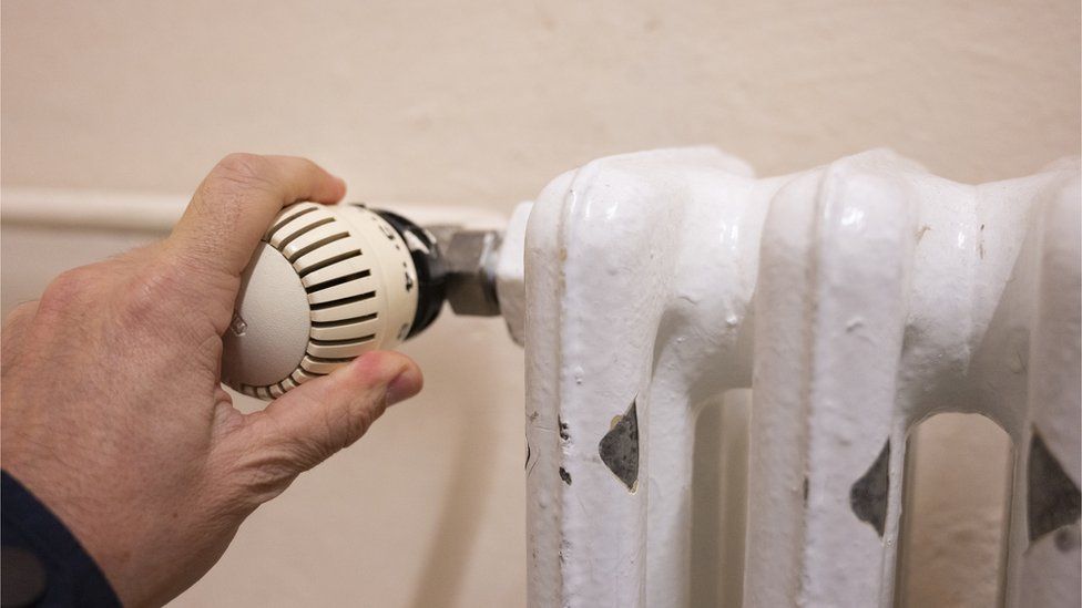 Person turning thermostat