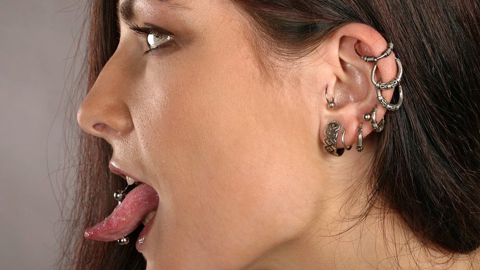 A women with ear and tongue piercings