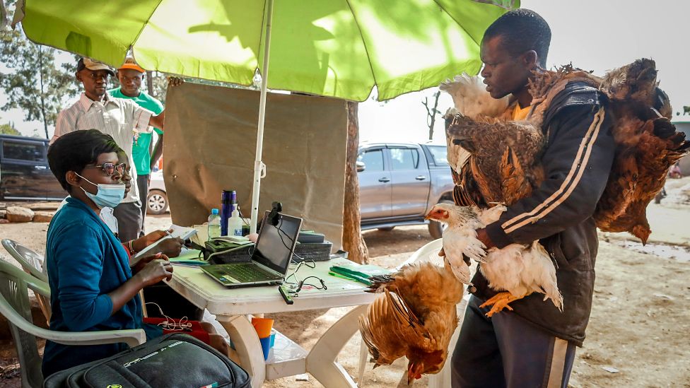 A man holding chickens talking to Independent Electoral and Boundaries Commission (IEBC) officials in Nairobi, Kenya - Tuesday 25 August 2022