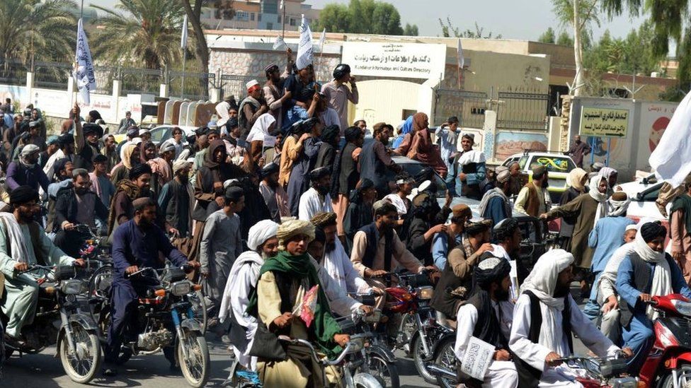 Taliban supporters celebrate along a street in Kandahar on August 31, 2021