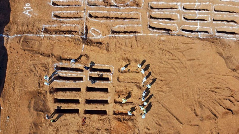 An aerial view shows Libyan experts exhuming human remains from mass graves in Tarhuna, southeast of the capital Tripoli, on October 28, 2020. - Libya's General Authority for the Search and Identification of Missing Persons reported yesterday that 12 unidentified bodies were recovered in the Rabt project area in Tarhuna.