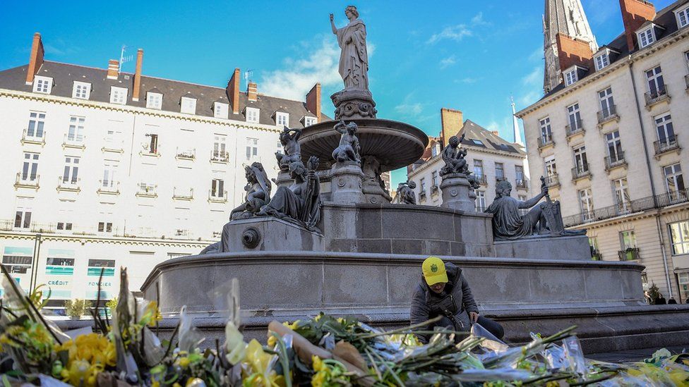 A FC Nantes football club supporter places flowers in the main square of the city of Nantes