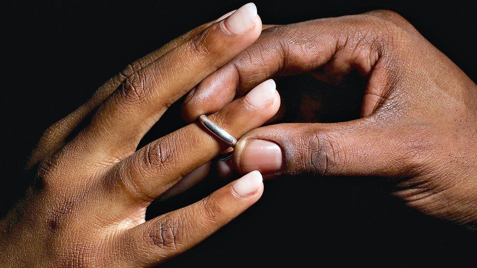 Man placing a ring on a woman's finger - generic shot