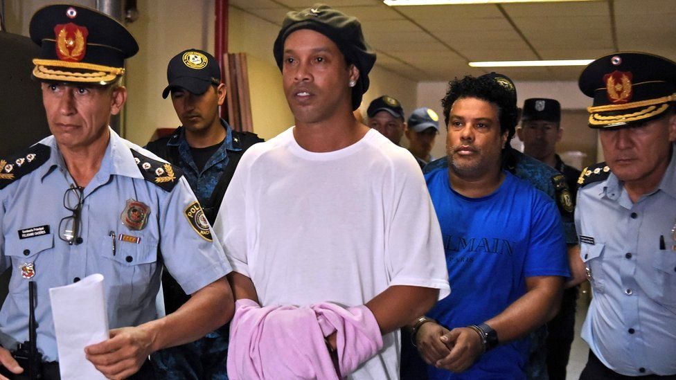 Retired Brazilian football player Ronaldinho (C) and his brother Roberto Assis (R) arrive at Asuncion's Justice Palace to appear before a public prosecutor who will decide whether to grant them bail or not following their irregular entry to the country, in Asuncion, 7 March 2020