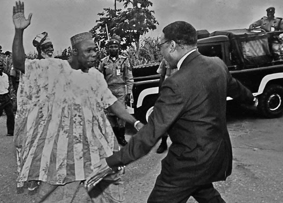 A photo by Sunmi Smart-Cole entitled: "How to be a Nigerian" - 1998, showing former military leader Olusegun Obasanjo (L) pictured a week after he left prison greeting Emeka Anyaoku, then secretary-general of the Commonwealth