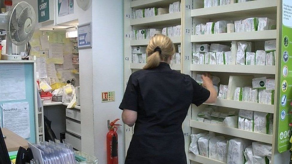 Staff member looking at prescriptions at pharmacy