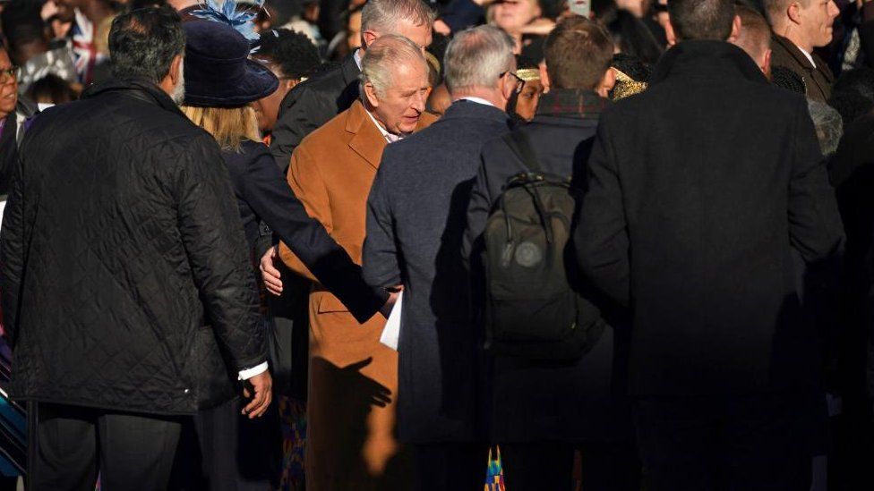 King Charles is ushered away from the scene by close protection officers