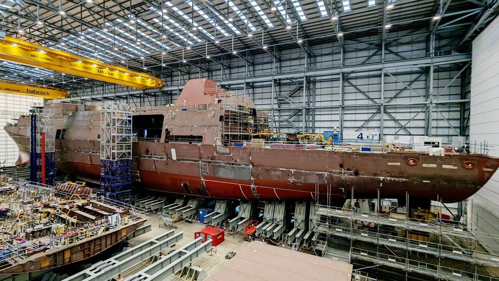 HMS Venturer under construction as it is lifted by 84 hydraulic jacks for weighing.