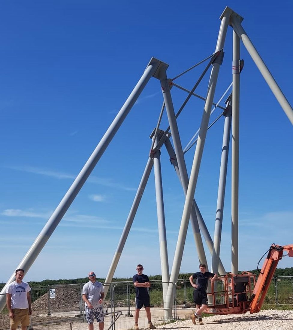 Men standing in front of a steel support structure