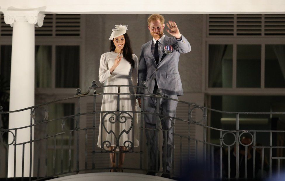 Prince Harry, Duke of Sussex and Meghan, Duchess of Sussex wave from the balcony of the Grand Pacific Hotel in Suva October 23, 2018