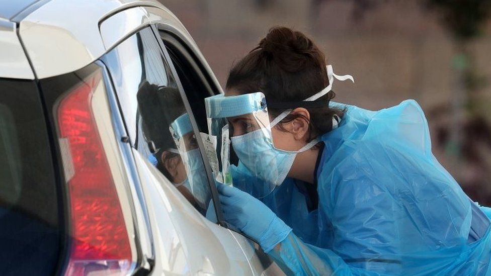 A nurse prepares to take a sample at a COVID 19 testing centre