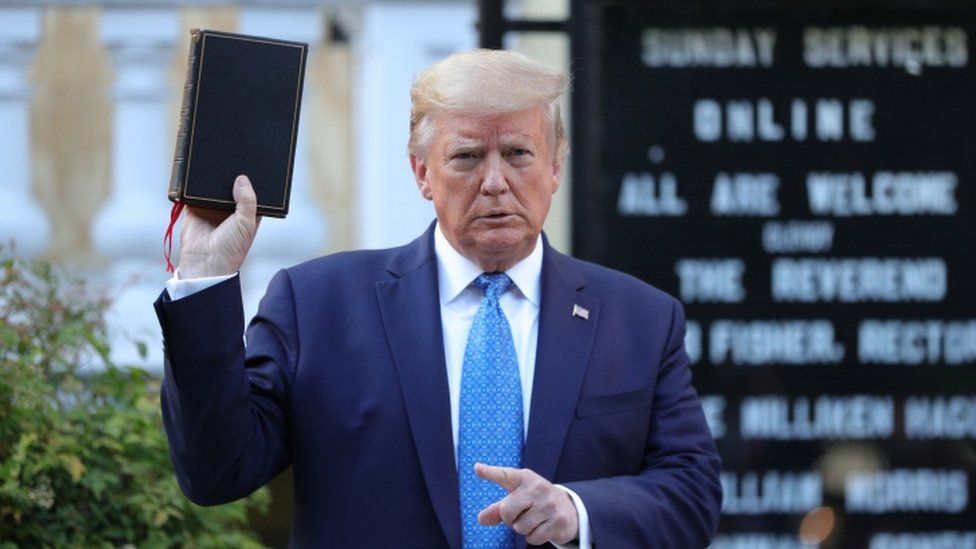 Donald Trump holding a Bible in front of a church