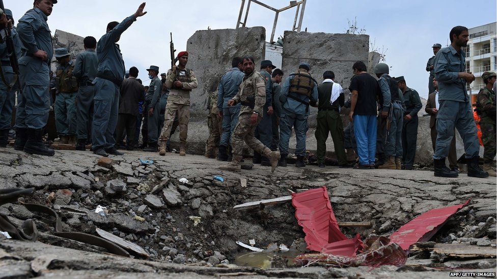 Afghan security personnel stand at the scene of a suicide attack by Taliban militants on the Afghan parliament building in Kabul on June 22, 2015.