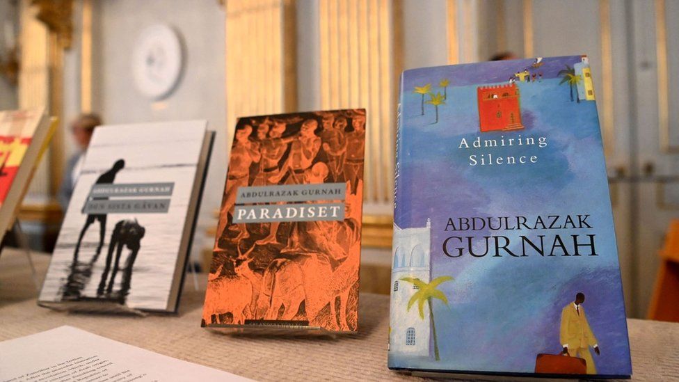 Three books are in view, they include the titles: Admiring Silence and Paradiset. The books are displayed on a table