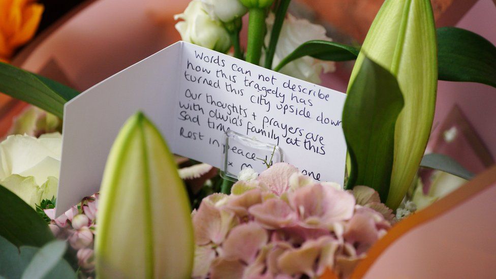 Flowers left near where the incident happened with a note card