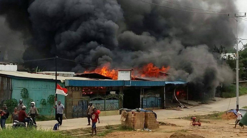 A building, set on fire by rioting demonstrators, is seen in Sorong