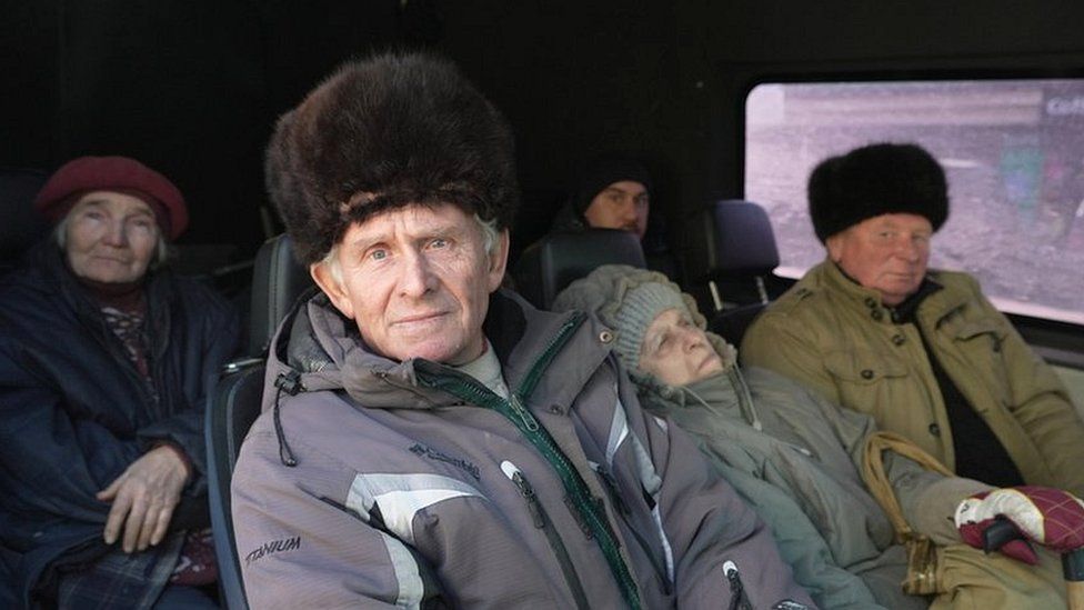 People from Avdiivka leave in a van for safety