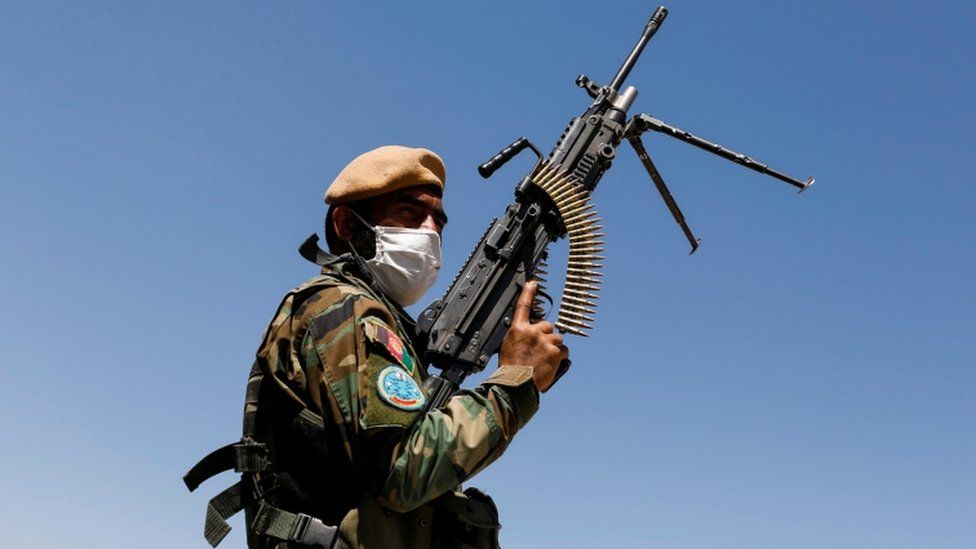 An Afghan National Army soldier holds a machine gun at a checkpoint on the outskirts of Kabul