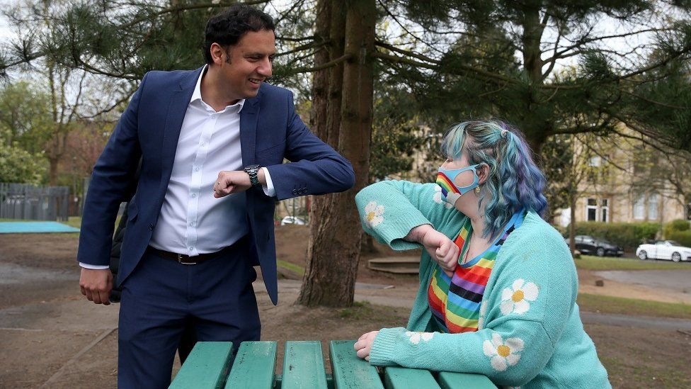 The Scottish Labour leader Anas Sarwar bumps elbows with a woman dressed in a green coat