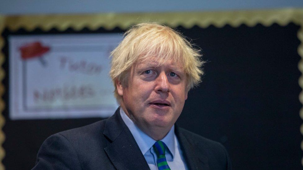 Boris Johnson wearing a school tie on a visit in August 2020