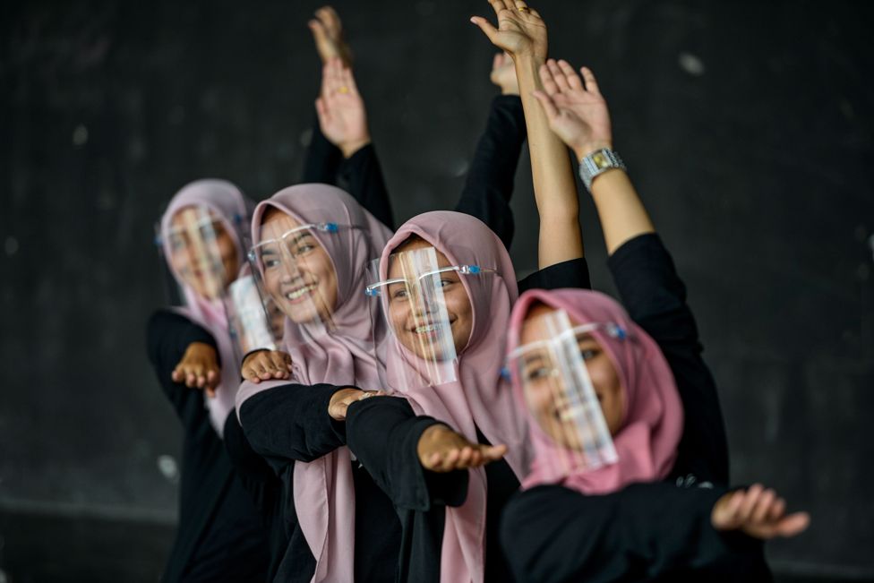 Dancers wearing face shields perform during a rehearsal