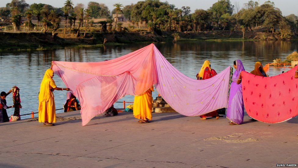 Women dry sarees on the bank of the holy river Shipra in Ujjain, Madhya Pradesh.