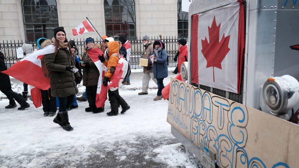 People gather along with truck drivers to block the streets during an anti-government and anti-vaccine mandate protest on February 12, 2022 in Ottawa, Ontario, Canada. The protest has entered the 16th day of blockading the area around the Parliament building in Canada’s capital.