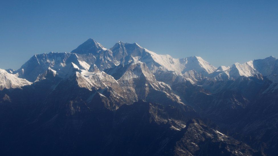 Mount Everest, the world"s highest peak, and other peaks of the Himalayan range are seen through an aircraft window during a mountain flight from Kathmandu, Nepal.