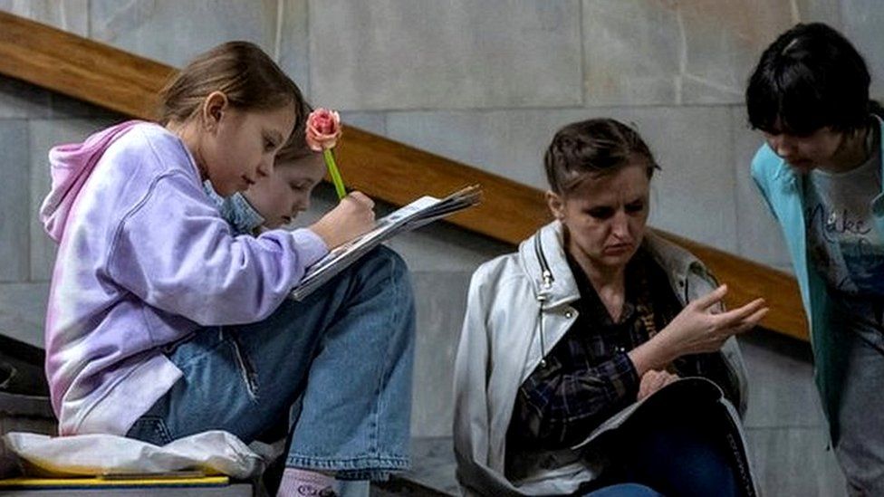 Students attend a lesson inside a Kyiv metro station during an air raid alert