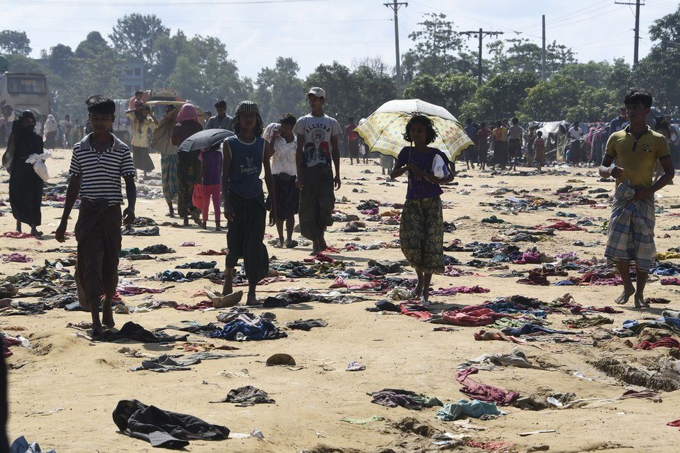 Rohingya Muslim refugees walk past discarded clothing on the ground at the Bhalukali refugee camp near Ukhia, 16 September