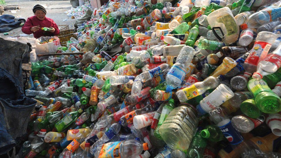 A worker sorts through various plastic bottles collected at a recycling collection centre in Hefei, 2012