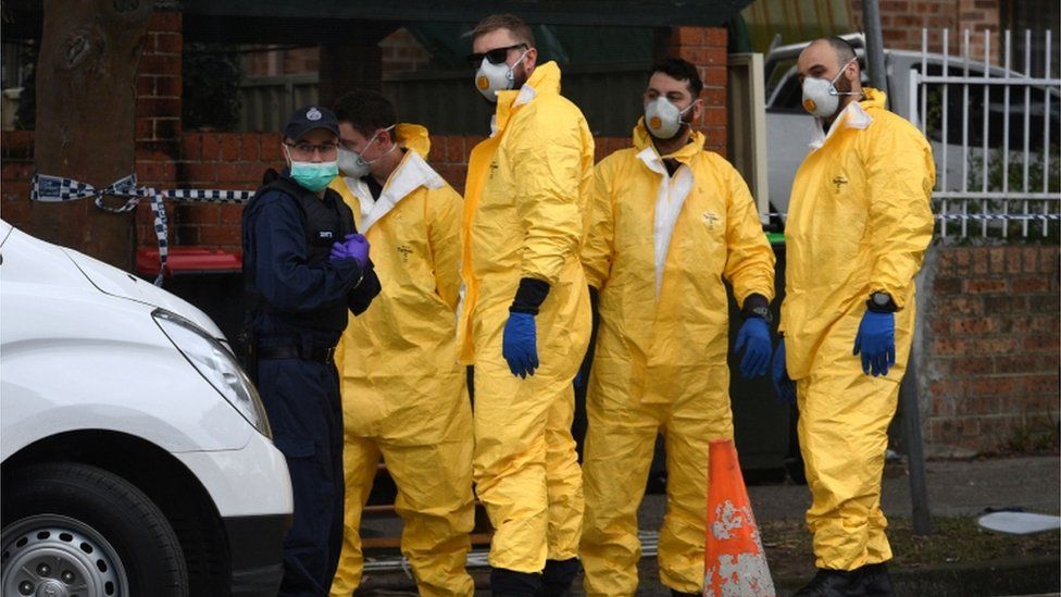 Workers in protective clothing outside a Sydney address