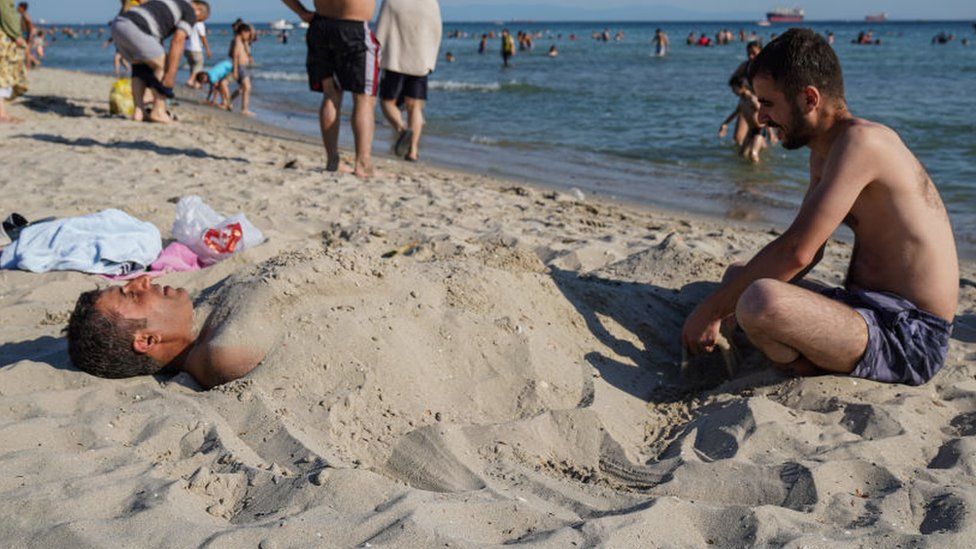Man buried in sand on the beach in Turkey