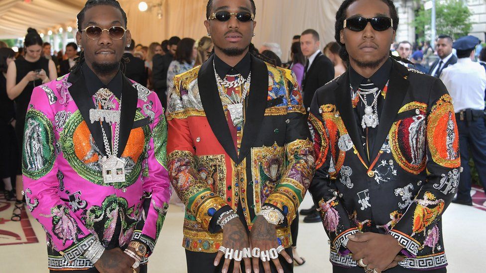 Takeoff, Offset, and Quavo of American hip hop trio Migos arrive in vibrant tuxedos.