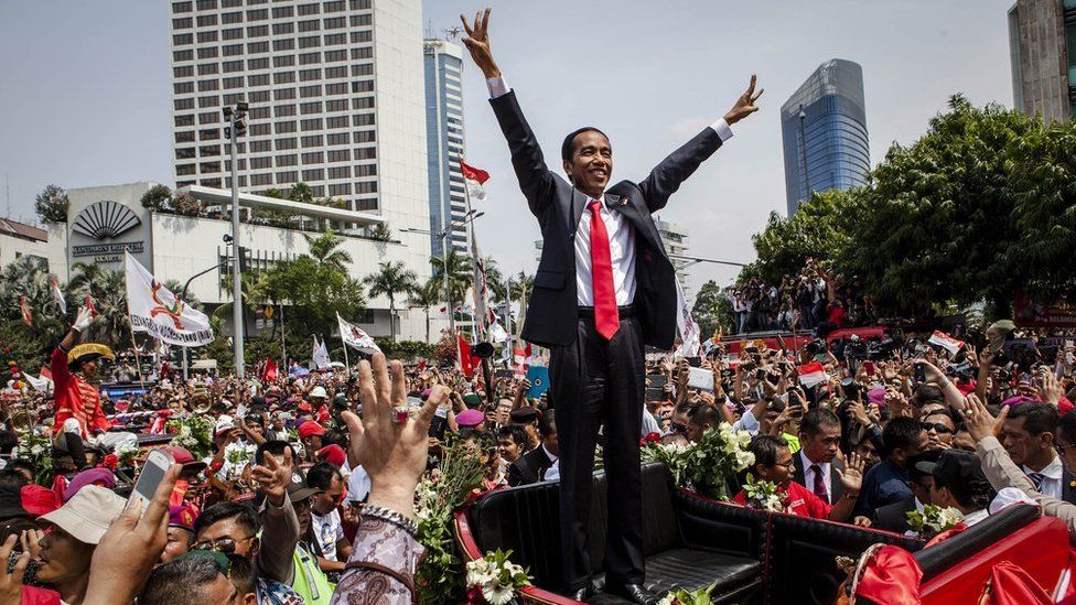 Indonesian President Joko Widodo waves to the crowd while on his journey to the Presidential Palace by carriage during the ceremonial parade on 20 October 2014 in Jakarta, Indonesia.