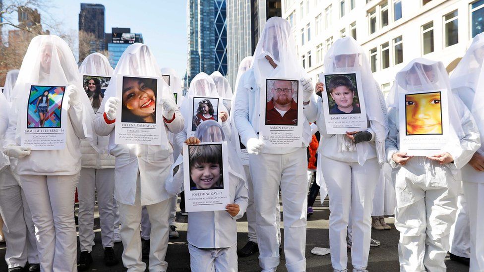 Protesters hold photos of victims of school shootings during a "March For Our Lives" demonstration demanding gun control in New York City