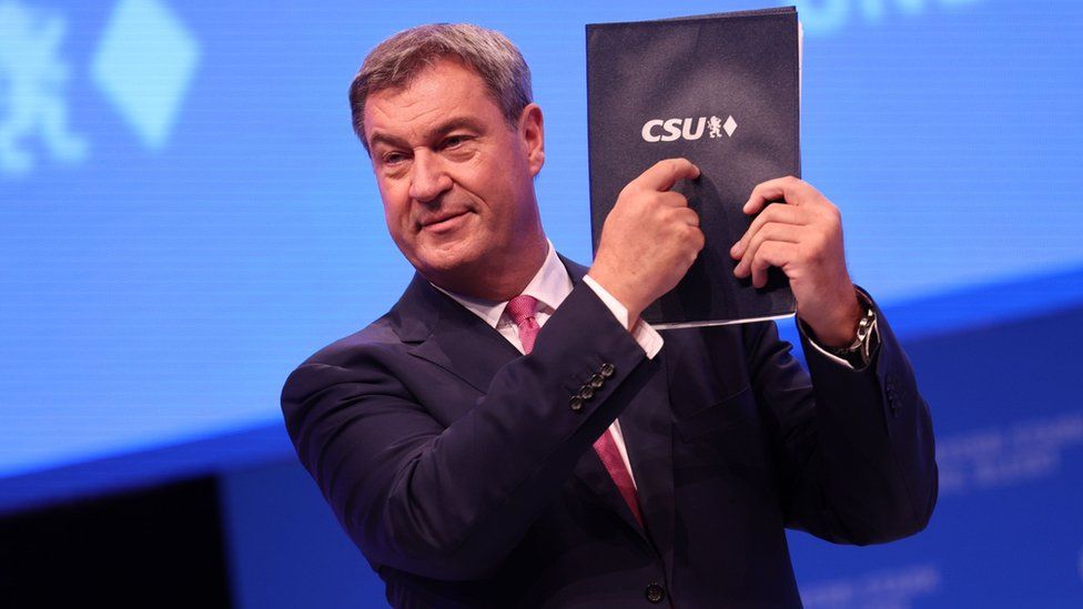 Bavarian Premier Markus Söder points at a party programme at his Christian Social Union (CSU) party conference