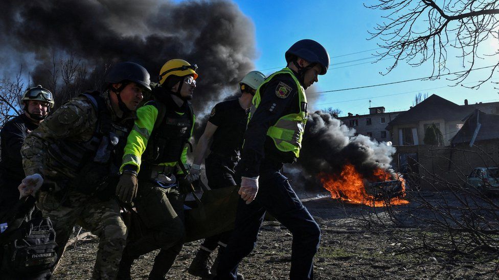 Emergency workers carry an injured woman at the site of a Russian missile strike in Zaporizhzhia