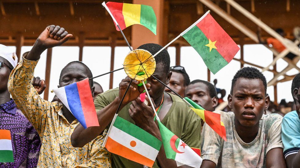 Man holding flags of Mali, Burkina Faso, Algeria, Niger and Russia in Niamey, Niger, 26 August 2023