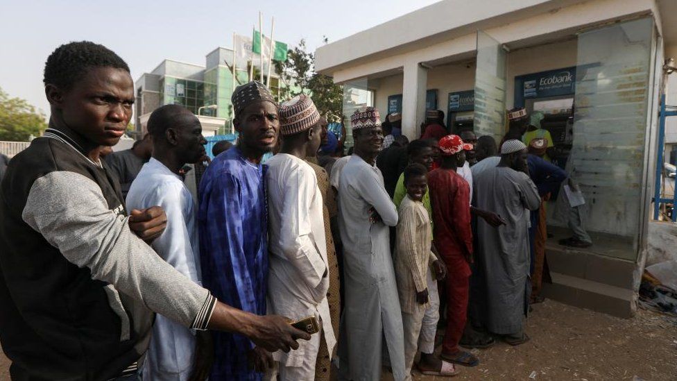 People queue to withdraw cash from an automated teller machine (ATM) at a bank, ahead of presidential elections, in Zamfara, Nigeria February 8