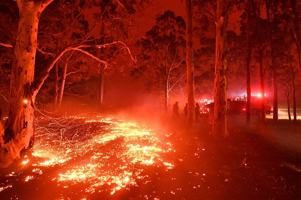 Burning embers cover the ground as firefighters battle against bushfires