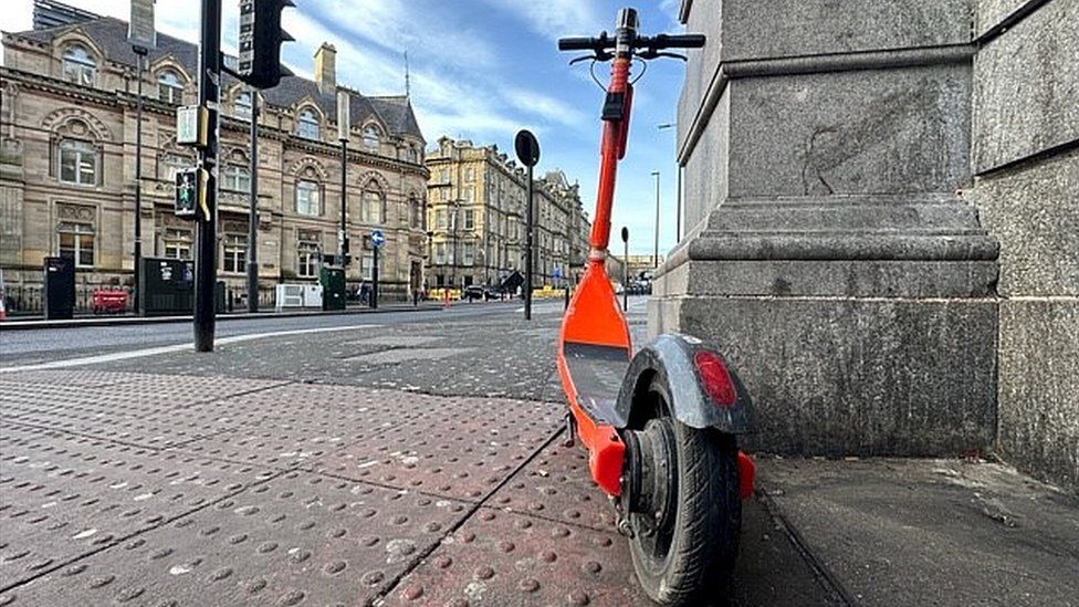 A scooter next to a pedestrian crossing