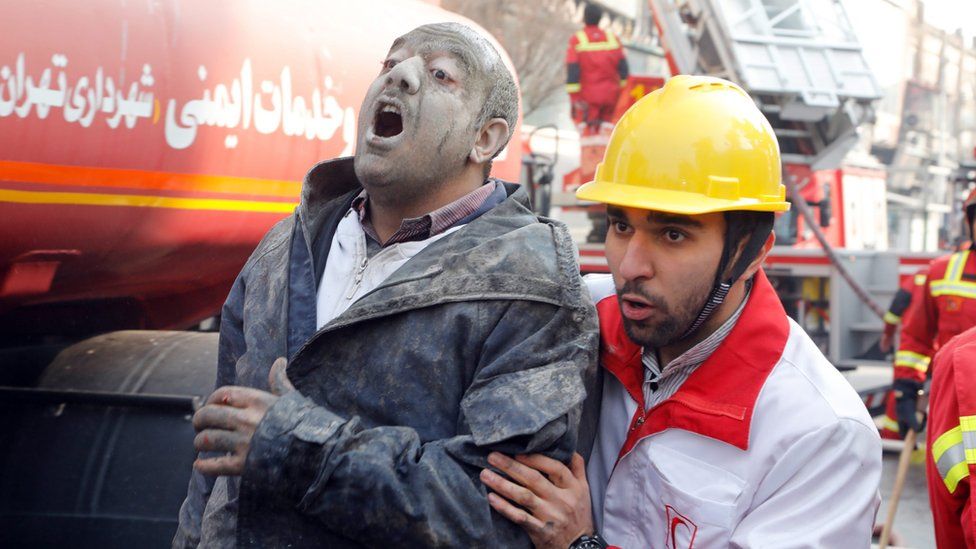 Rescue worker helps an injured man after building collapse in Tehran, Iran (19 January 2017)