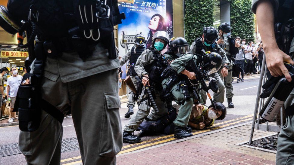 Riot police officers pinning down a protester during the demonstration following the passing of the National Security Law that would tighten freedom of expression