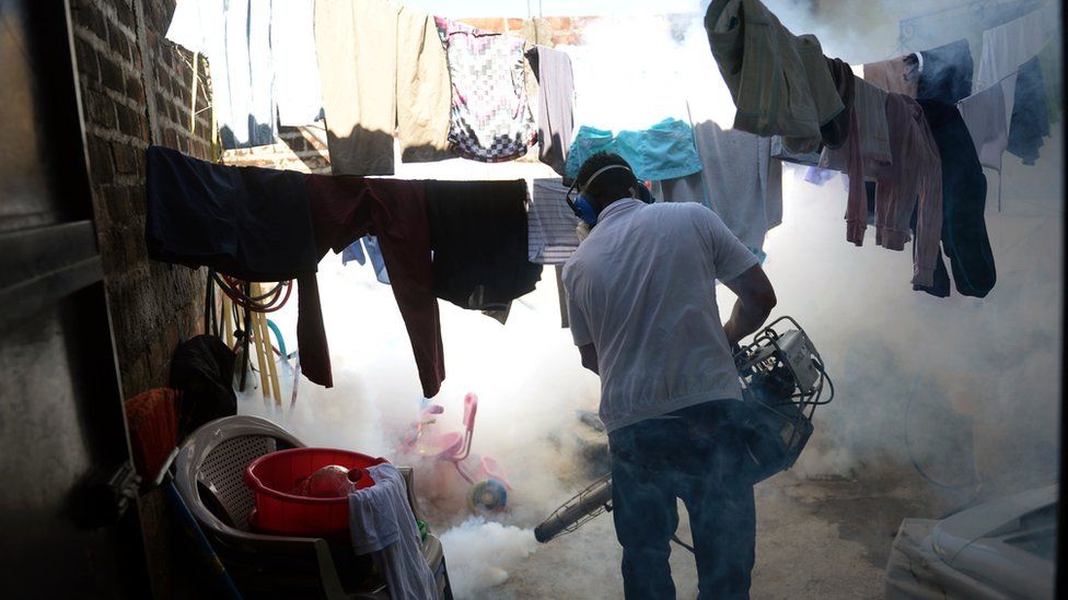 Public health officials fumigating a street in El Salvador.