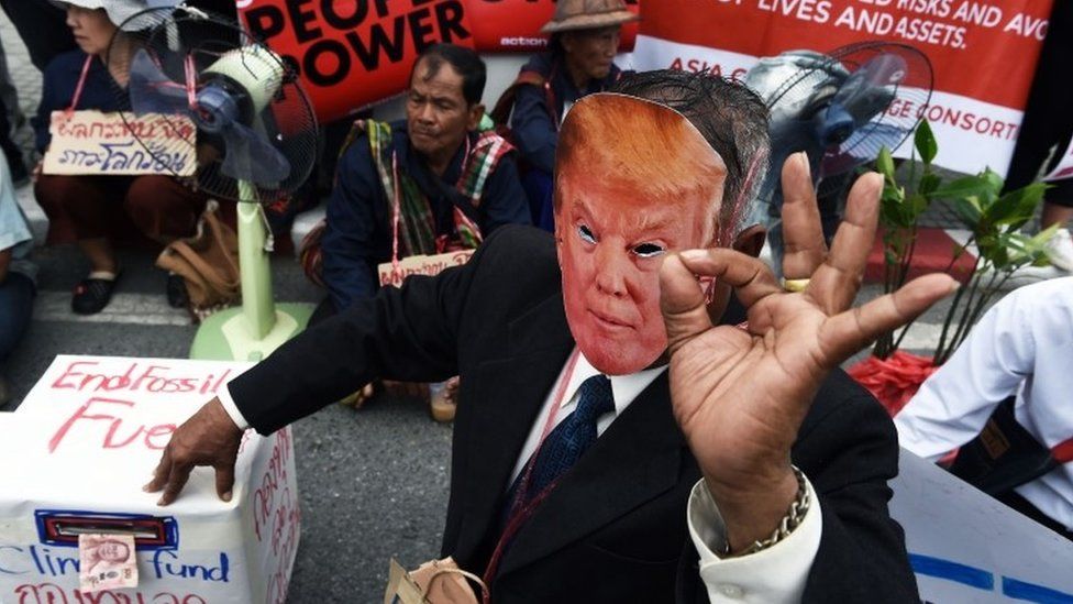 An environmental activist wearing a face mask depicting US President Donald Trump takes part in a demonstration in Bangkok, outside the UN building where experts are discussing the Paris Agreement on climate change, on 8 September 2018.