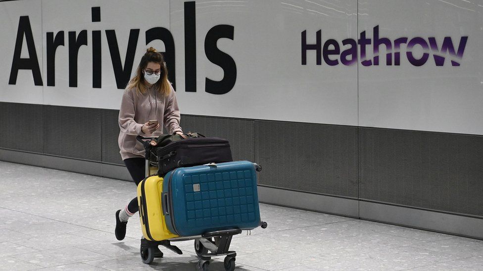 A woman arrives at Heathrow Aiport