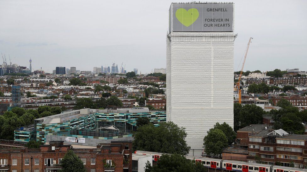 Grenfell Tower is seen shrouded by scaffolding and covers one year after the tower fire in London