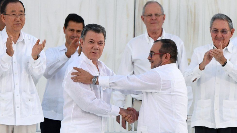 President Santos and Timochenko shaking hands after signing the deal