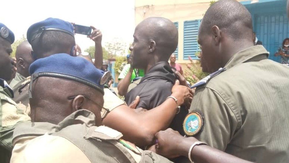 Baye Modou Fall being taken to the police station